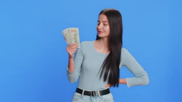裕福な幸せな白人の若い女性は ファン 成功したビジネスキャリア 宝くじの勝者 大きな収入の富のような紙幣を振ります 青い背景で孤立したティーンエイジャーガール — ストック動画