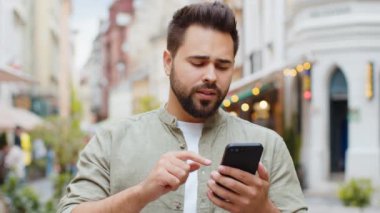 Beyaz sakallı adam akıllı telefon daktilo kullanıyor. Ani piyango sonuçlarını kaybediyor. Kötü haber, servet kaybı, başarısızlık. Şehir caddesinde yürüyen genç bir adam. Kasaba yaşam tarzları