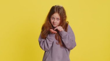 Biraz daha, lütfen bana ver. Genç bir kız çocuğu, küçük bir jest yapıyor, kuşkucu bir gülümseme takınıyor, minimum boyut gösteriyor, yalvarıyor. Sarı arka plandaki çocuklar