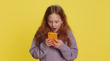 Genç kız çocuk cep telefonuyla yazı yazarak 