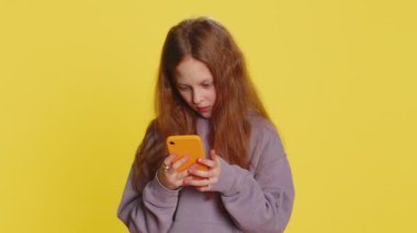 Genç kız çocuk cep telefonuyla yazı yazarak 