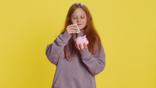 若い19歳の少女は 将来の教育のために ドルのポケットマネーをブタバンクに預ける コインボックス金融所得の成長 黄色の背景で孤立した経済を持つティーンエイジャーの子供たち — ストック動画