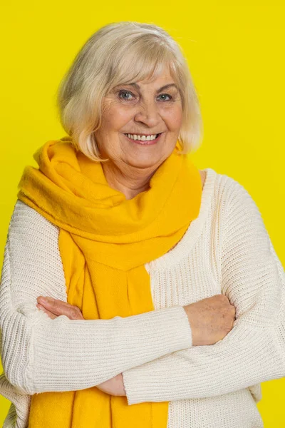 Portrait of happy senior old woman smiling friendly glad expression looking at camera dreaming resting relaxation feel satisfied good news. Elderly grandmother pensioner on yellow background. Vertical