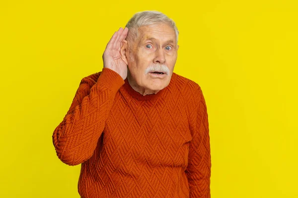 I cant hear you. What. Senior old man trying hear you, looking confused and frowning keeping arm near ear for louder voice asking to repeat to hear information deafness. Elderly pensioner grandfather
