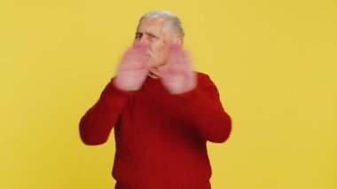 Hiçbir şey söylemeyeceğim. Korkmuş kıdemli adam elleriyle ağzını kapatıyor, kamera karşısında korkmuş görünüyor. Gizli inanılmaz gerçeği söylemeyi reddetmiyor. Büyükbaba sarı arka planda.