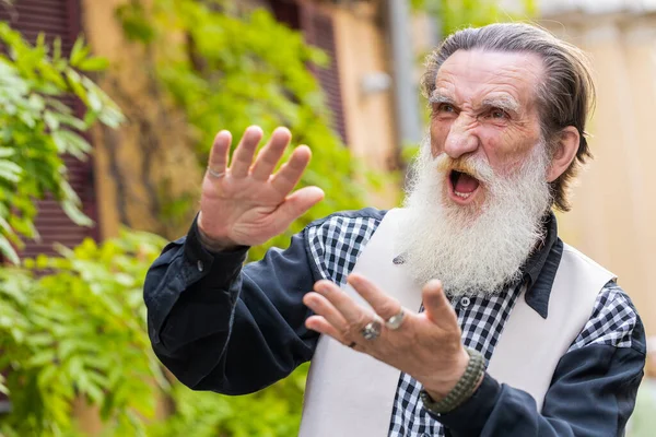 Cheerful rich bearded elderly man showing wasting throwing money around hand gesture, more tips earnings, big profit, win lottery, share, celebrate outdoors. Senior grandfather standing in city street