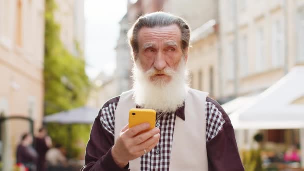 Feliz Sorridente Idoso Sênior Usando Smartphone Digitando Mensagens Texto Navegando — Vídeo de Stock