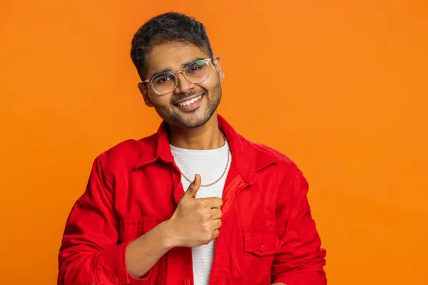 Like. Indian man raises thumbs up agrees with something or gives positive reply recommends advertisement likes good idea feedback, celebrating success victory. Arab guy isolated on orange background