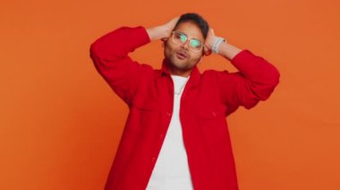 Üzgün genç Hintli adam umutsuzluk yalnızlık, sinir bozukluğu, kaybediyor piyango sonuçları, kötü talih, şanssız haberler karşısında şaşırıyor. Çekici Hindu adam turuncu arka planda izole edilmiş.