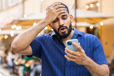 Hintli sakallı adam akıllı telefon daktilo kullanıyor. Ani piyango sonuçlarını kaybediyor. Kötü haber, servet kaybı, başarısızlık. Şehir caddesinde yürüyen genç bir adam. Kasaba yaşam tarzları