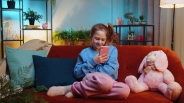 Akıllı telefon sosyal medya uygulamaları üzerinden mesajlaşan genç kız rahatlama filmi izliyor. Genç bir kız, akşam yemeğinde evde cep telefonu kullanıyor. Kanepeye oturuyor.