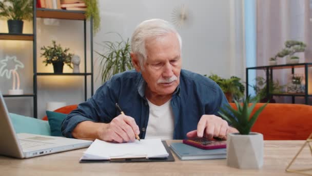 Starszy Mężczyzna Płaci Rachunki Obliczając Miesięczne Wydatki Rachunki Bankowe Analizując — Wideo stockowe