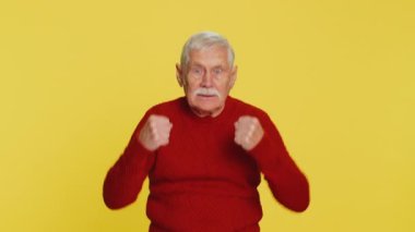 Sinirli, sinirli yaşlı bir adam. İnançsızlığını dile getiriyor. Sıkılmış, hayal kırıklığına uğramış, kötü haber, kavga, stres. Sarı arka planda kızgın yaşlı büyükbaba emeklisi
