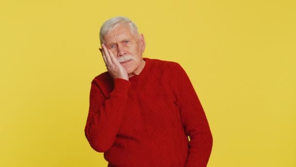 만지는 끔찍한 표현으로 고통스러운 민감한 구멍에서 노란색 배경에 할아버지 은퇴자 — 비디오