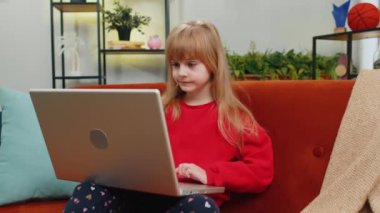 Şaşırmış genç kız çocuk dizüstü bilgisayar kullanıyor, iyi haber mesajı alıyor, ani zaferle şok oluyor, oyun kazancını kutluyor, piyango ikramiyesini kazanıyor, evden online alışveriş yapıyor. Yaşam Tarzları