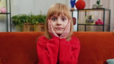Aman Tanrım, vay canına. Kafkasyalı şaşkın liseli kız kameraya büyük gözlerle bakıyor, ani bir zafer, iyi bir galibiyet haberi, kutlama. Evdeki kanepede oturan heyecanlı çocuk.