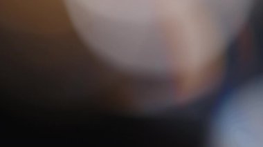 Çok renkli ışık siyah arkaplanda 4K görüntü sızdırıyor. Stüdyoda gaz sızıntısı var. Doğal aydınlatma ışınları bokeh etkisi. Çekimlerinizi birleştirmek, videoyu biçimlendirmek, geçişlerinizi