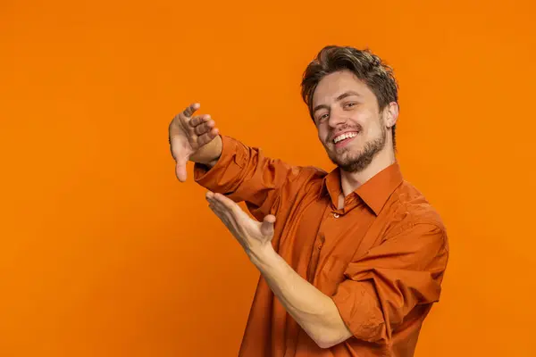 Caucasian man showing wasting throwing sharing money around, more tips, big profit, winning lottery jackpot, successful shopping payment purchase cashback. Handsome guy isolated on orange background