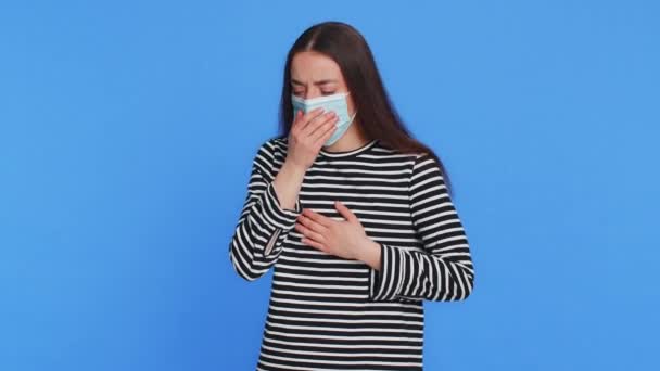 手で口をカバーする不健康な若い女性 アレルギーまたはウイルス感染症の症状 発熱痛ウイルスを感じます ブルースタジオの背景で孤立したかなり魅力的なブルネットガール — ストック動画