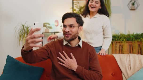 Diverse Gelukkige Indiase Paar Zwaaien Hallo Tijdens Het Praten Smartphone — Stockvideo