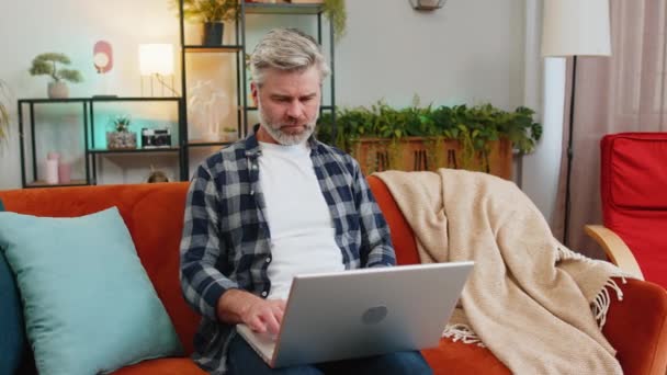 Evdeki Koltukta Oturan Gri Saçlı Üzgün Yaşlı Adam Dizüstü Bilgisayar — Stok video