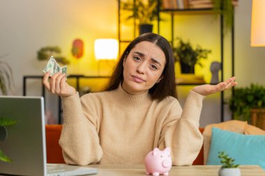 Zavallı Kafkas genç kadın, yetersiz miktarda para, kumbarası ve bir dolar banknotu var. Finansal kriz. İflas. Yoksulluk ve yoksulluk. Masada oturan bir bayan kız.