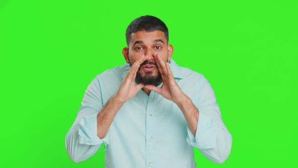 秘密を守って 黙ってろ インド人男性は 口の近くで手を握り ゴシップを共有し 静かにするというニュースをささやいた 緑色のクロマのキーバックで隔離された興味深い秘密の物語を話す男 ライフスタイル — ストック動画