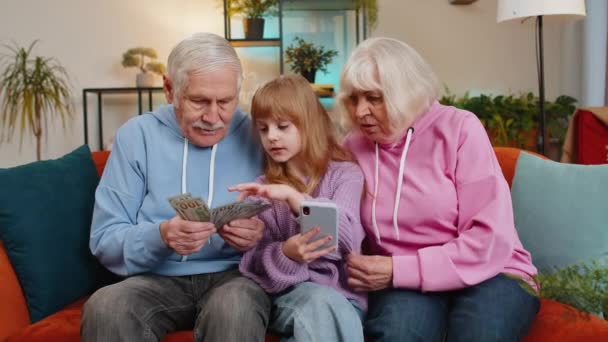 Dziadek Kaukaski Babcia Wnuczka Liczą Pieniądze Pomocą Kalkulatora Smartfonów Domu — Wideo stockowe
