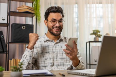 Akıllı telefon daktilo kullanarak mutlu Hintli işadamı, 