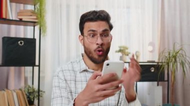 Aman Tanrım, vay canına. Mutlu, genç İspanyol iş adamı akıllı telefon üzerinde çalışırken piyango galibiyet oyunu kazanma uygulaması ve iyi haberler karşısında şok oldu. Merkez ofisteki Hintli serbest çalışan adam..