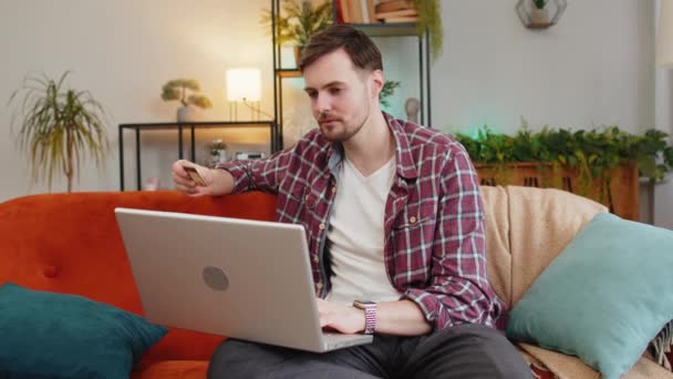 Joven Hombre Triste Camisa Cuadros Sentado Sofá Utilizando Ordenador Portátil — Vídeos de Stock