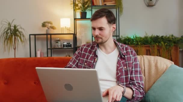 Ung Man Sitter Soffan Stänga Laptop Efter Avslutad Arbete Vardagsrummet — Stockvideo