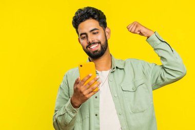 Mutlu Hintli genç adam akıllı telefon daktilo kullanıyor ve bağırıyor 