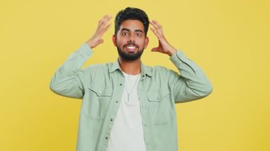 Gerginlikten bağıran sinirli Hintli adam korku, umutsuzluk, şaşkınlık şokun öfkesini ve kavgasını hisseder. Sarı stüdyo arka planında izole Arap genç adam