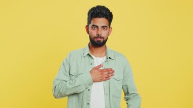 Dürüst olacağıma yemin ederim. Saygıdeğer sorumlu Hintli adam yemin etmek için elini kaldırıyor, dürüst olacağına, doğruyu söyleyeceğine, elini göğsüne koyacağına, adalete dokunacağına söz veriyor. Sarı stüdyo arka planında izole edilmiş bir Arap.
