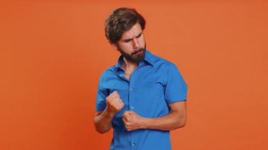 Sinirli, sinirli, genç, Ortadoğulu bir adam öfkeli bir ifadeyle el kaldırıyor, kavga ediyor, çatışma nedenini soruyor, neden bu kadar inatçısın? Arap adam turuncu stüdyo arka planında izole edilmiş.