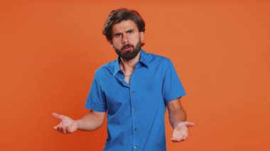 Avuç içi. Yazıklar olsun sana. Ortadoğulu üzgün bir genç adam, palmiye jesti yapıyor. Sıkılmış, hayal kırıklığına uğramış, kötü, kederli. Turuncu stüdyo arka planında izole edilmiş mutsuz bir adam.