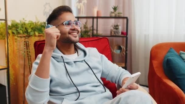 Щасливий Розслаблений Індійський Арабський Чоловік Бездротових Навушниках Який Танцює Стільці — стокове відео