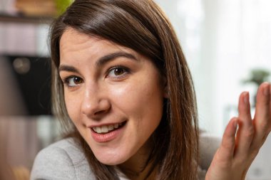 POV webcam görüntüsü genç Kafkasyalı iş kadını yöneticisi kameraya bakıyor ve iş yerindeki akıllı telefon kamerasıyla online toplantı konferans görüntüleriyle konuşuyor. Uzak görev çevrimiçi.