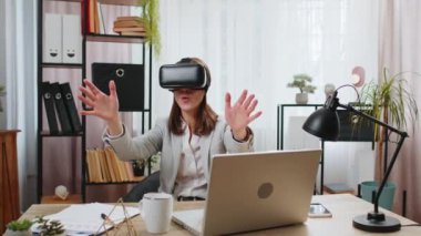 Sanal gerçeklik teknolojisi VR uygulamasını kullanarak modern ofis masasındaki 3D 360 video simülasyonunda heyecanlı genç iş kadını. Kadın Yönetici Serbest Çalışan Çevrimiçi Jest Yapıyor.