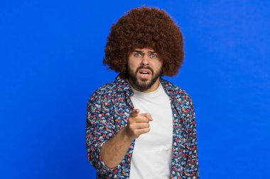 Tartışma. Afro saç stili peruklu, rahatsız edici elleri olan hoşnutsuz, mutsuz ve mutsuz bir adam bunun neden olduğunu sormakta başarısız olduğu için azarlıyor. Mavi arkaplanda izole edilmiş adam