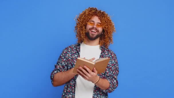 Happy Relaxed Smiling Man Curly Hairstyle Wig Reading Funny Interesting — Stock Video
