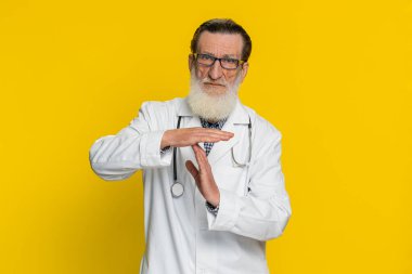 Yaşlı bir kardiyolog olan yaşlı bir adamın mola vermesi, durması ya da durması, dinlenmesi, dinlenmesi, yardım etmesi beni çok üzdü. Eczacı dedesi sarı arka planda izole edilmiş.