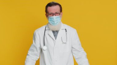 Mutlu kıdemli doktor kardiyolog koruyucu maskeyi çıkartıyor. Grip tedavisi. Salgın karantina sona eriyor. Eczacı eczanesi. Yaşlı büyükbaba sarı arka planda izole edilmiş.