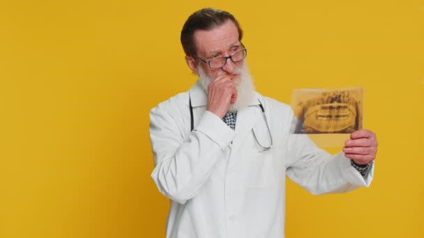 Anciano Ortodoncista Examina Una Imagen Panorámica Rayos Los Dientes Mandíbula — Vídeo de stock