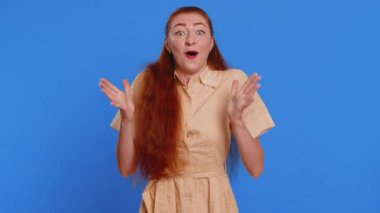 Aman Tanrım, vay canına. Heyecanlı kazanan kadın şaşkınlıkla el kaldırıyor. Büyük gözleriyle kameraya bakıyor. Ani zaferden şok oluyor. Samimi kızıl saçlı yetişkin kız mavi stüdyoda tek başına.