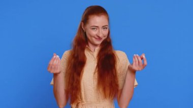 Harcanan, etrafa para saçan genç bir kadın, daha fazla bahşiş, büyük kazanç, piyango ikramiyesi, başarılı alışveriş ödemesi nakdi. Kızıl saçlı yetişkin kız mavi stüdyo arka planında izole edilmiş.