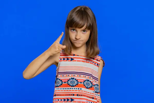 Quarrel. Displeased young cute brunette school girl gesturing hands with irritation and displeasure, blaming scolding for failure, asking why this happened. Preteen female child kid on blue background
