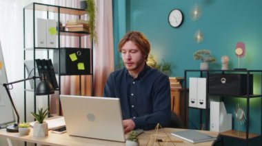 Huzurlu ve rahat genç erkek işadamı işyerinde Mudra el hareketleriyle katlanmış şekilde oturuyor, iş günlerinde stresi azaltıyor, meditasyon yapıyor ya da evde yoga solunum egzersizleri yapıyor..