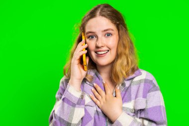 Telefon, iyi haber, dedikodu. Akıllı telefondan hoş sohbetlere katılan mutlu, beyaz bir kadın, arkadaşıyla konuşmaktan zevk alıyor. Kızıl saçlı kız yeşil krom anahtar arka planında izole edilmiş.